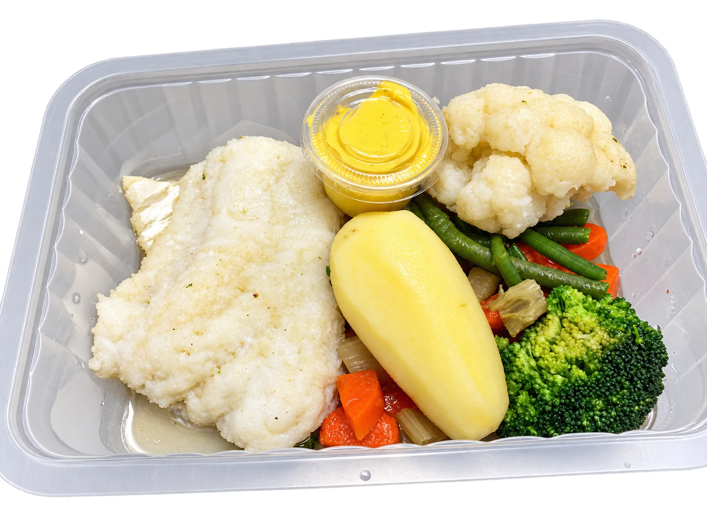 Une barquette transparente contient un filet de poisson blanc, une pomme de terre, du chou-fleur, du brocoli, des haricots verts, des carottes et une petite coupelle de sauce jaune.